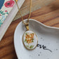 Collier ovale en acier inoxydable doré - décoré avec un morceau de vaisselle surcyclé - Fleurs oranges et jaunes