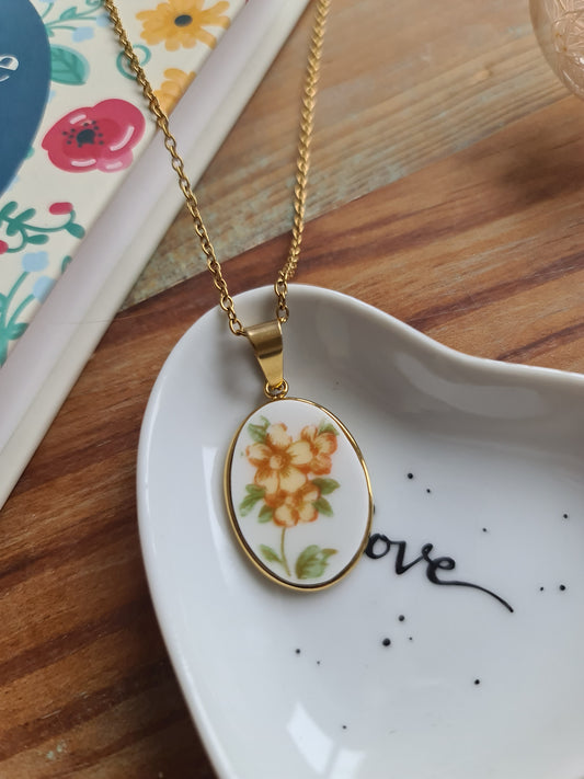 Collier ovale en acier inoxydable doré - décoré avec un morceau de vaisselle surcyclé - Fleurs oranges et jaunes