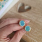 Boucles d'oreilles puce en laiton doré à l'or fin - décorées avec un morceau de vaisselle surcyclé - Fond turquoise