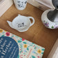Repose sachet de thé en porcelaine - décor pile de livres peint à la main